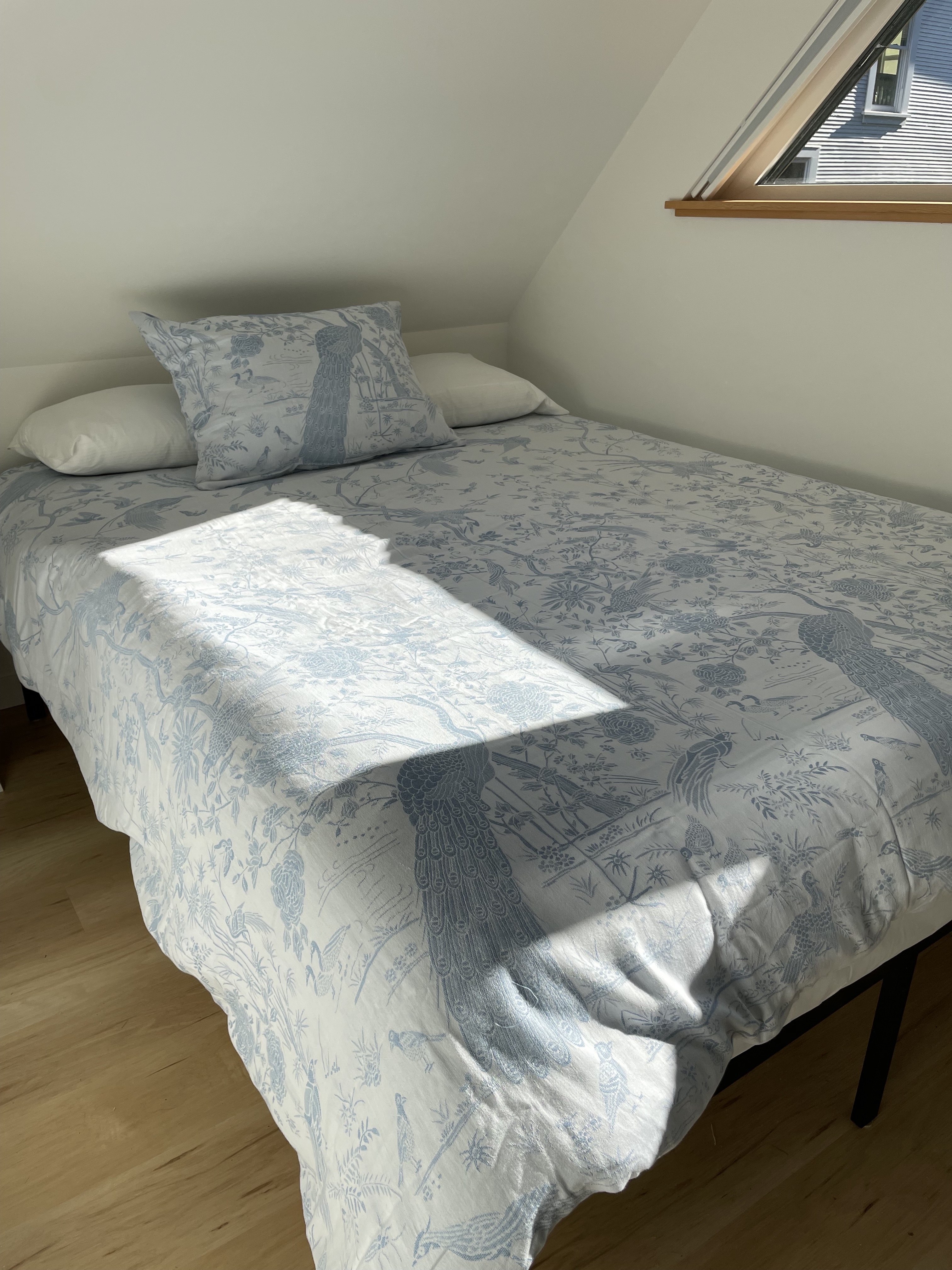 Soft bedroom linens and sunlit bed